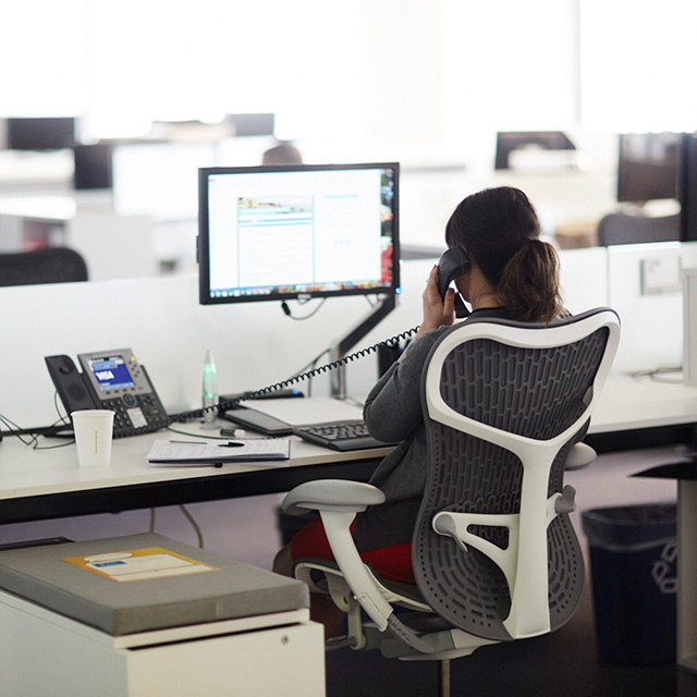 Woman sitting at her office desk while talking on the phone.